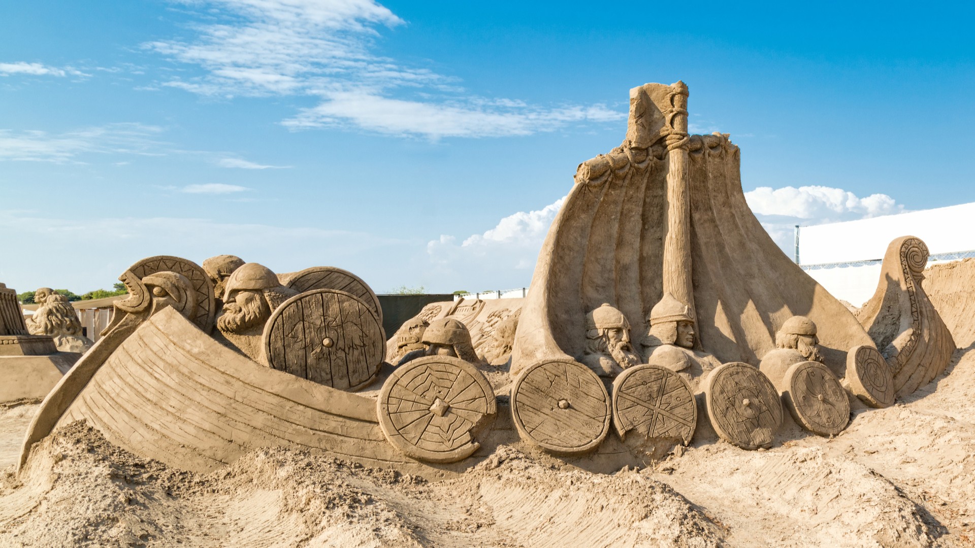 Песчаная скульптура викингского корабля с изображением мифических персонажей в парке Sandland.