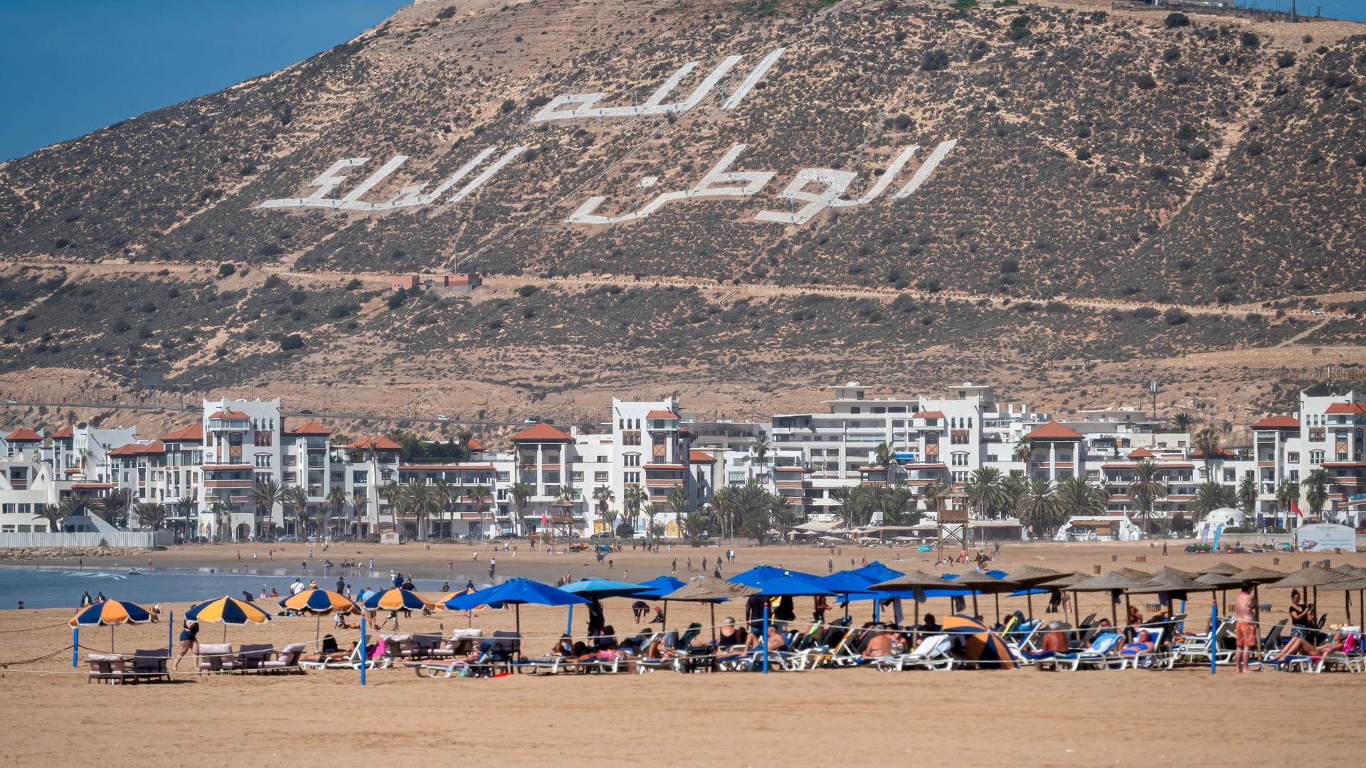 Пляж в Агадире и надпись на склоне холма: «Бог, Родина, Король».