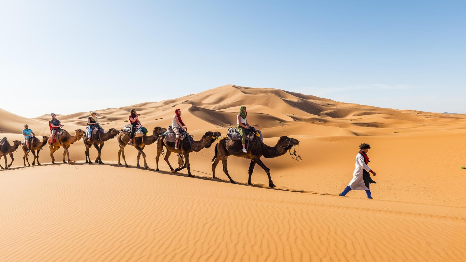 Караван проезжает через песчаные дюны в пустыне, Эрг-Шебби, Мерзуга.