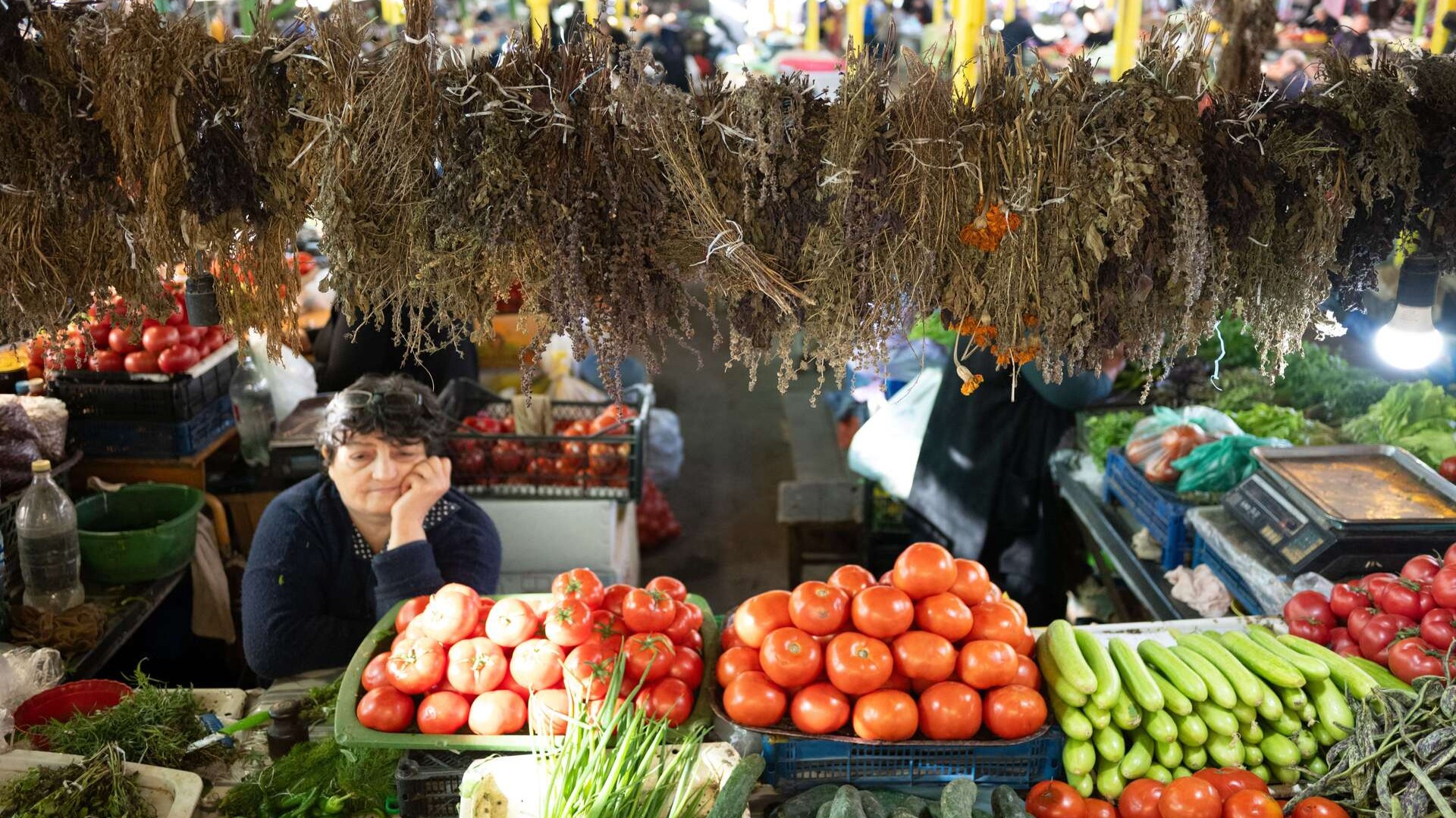 Женщина продает травы и овощи на рынке «Зеленый базар», Кутаиси.